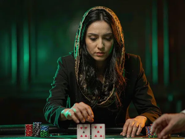 lucky777 Woman in a black blazer studies two face-up cards at a blackjack table
